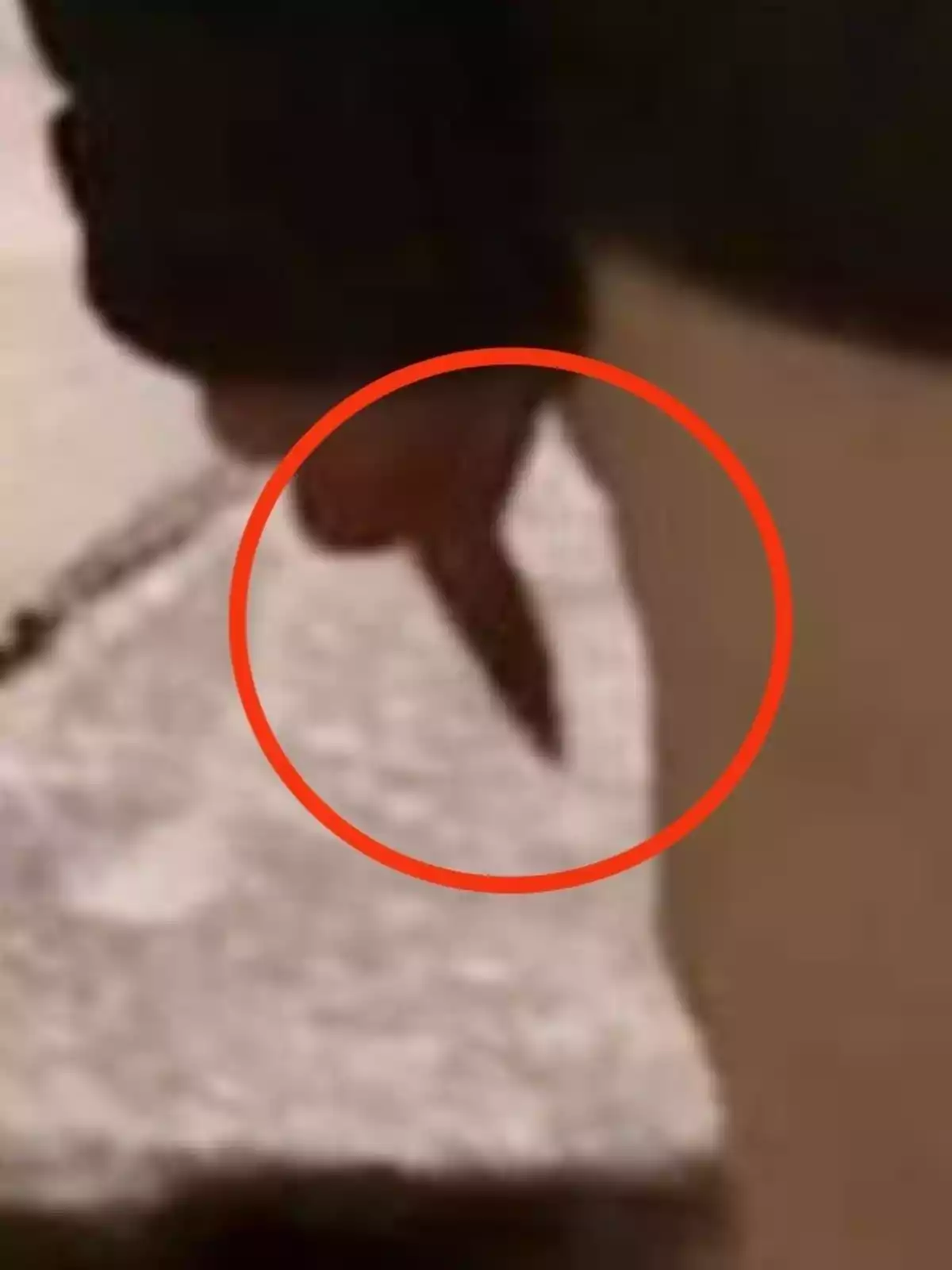 Mano sosteniendo un cuchillo con un círculo rojo resaltando el objeto Mano sosteniendo un cuchillo con un círculo rojo resaltando el objeto
