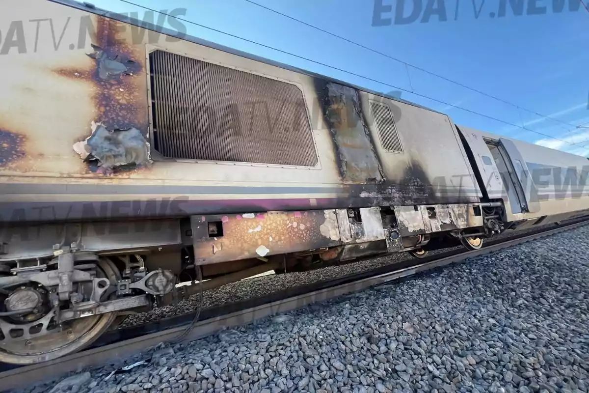 Tren con daños visibles por incendio en uno de sus vagones mientras está detenido sobre las vías Tren con daños visibles por incendio en uno de sus vagones mientras está detenido sobre las vías
