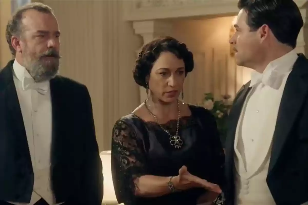 Alonso, Leocadia y Manuel elegantemente vestidas conversan en un ambiente formal y sofisticado. Captura de 'La Promesa' Alonso, Leocadia y Manuel elegantemente vestidas conversan en un ambiente formal y sofisticado. Captura de 'La Promesa'