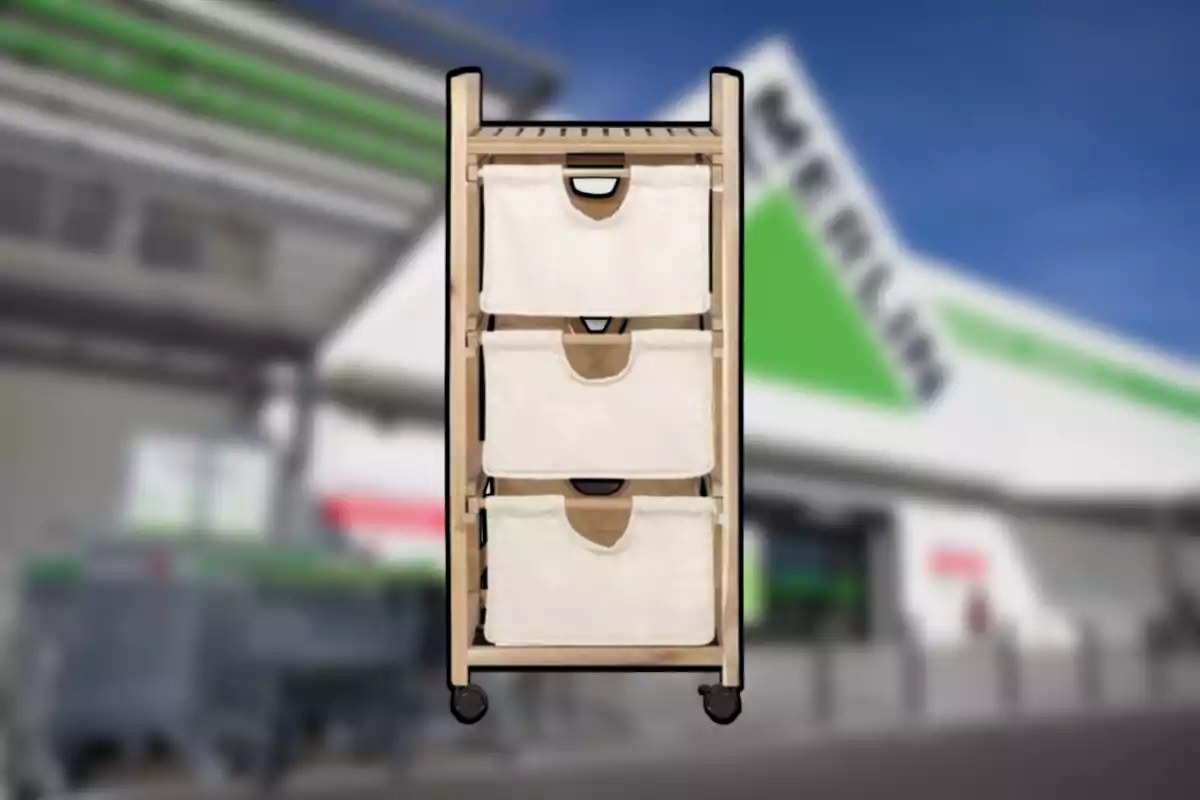 Carrito organizador de madera con tres cajones de tela beige y ruedas al frente de una tienda. Carrito organizador de madera con tres cajones de tela beige y ruedas al frente de una tienda.