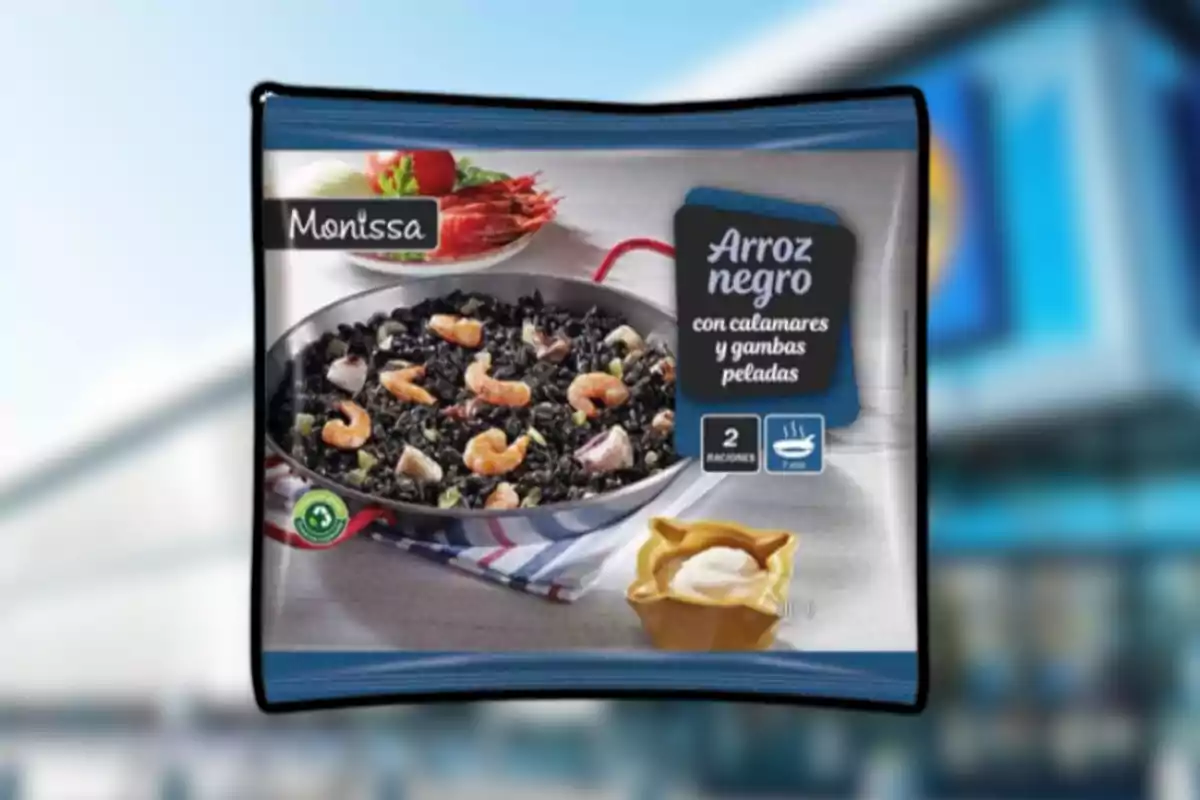 Paquete de arroz negro con calamares y gambas peladas de la marca Monissa mostrando una sartén con el platillo preparado y una pequeña porción de salsa a un lado Paquete de arroz negro con calamares y gambas peladas de la marca Monissa mostrando una sartén con el platillo preparado y una pequeña porción de salsa a un lado