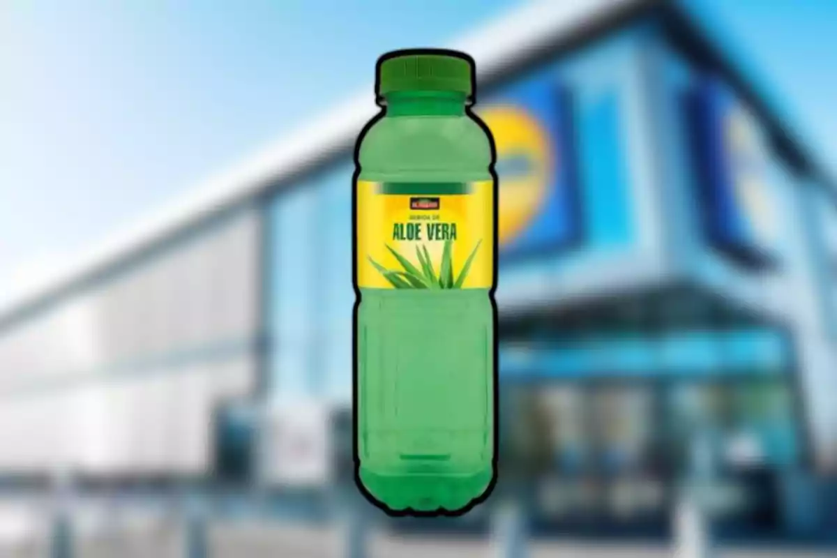 Botella verde de bebida de aloe vera con etiqueta amarilla frente a un supermercado desenfocado Botella verde de bebida de aloe vera con etiqueta amarilla frente a un supermercado desenfocado