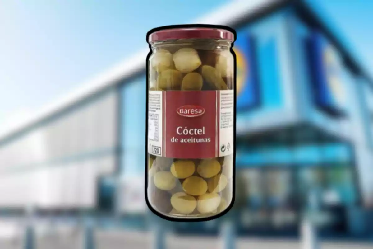 Frasco de cóctel de aceitunas Baresa frente a un supermercado desenfocado Frasco de cóctel de aceitunas Baresa frente a un supermercado desenfocado