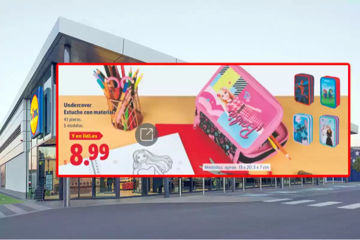 Publicidad de una tienda Lidl mostrando un estuche escolar con material de papelería y varios diseños infantiles, junto al precio de 8.99 euros, sobre el fondo de la entrada de la tienda. Publicidad de una tienda Lidl mostrando un estuche escolar con material de papelería y varios diseños infantiles, junto al precio de 8.99 euros, sobre el fondo de la entrada de la tienda.