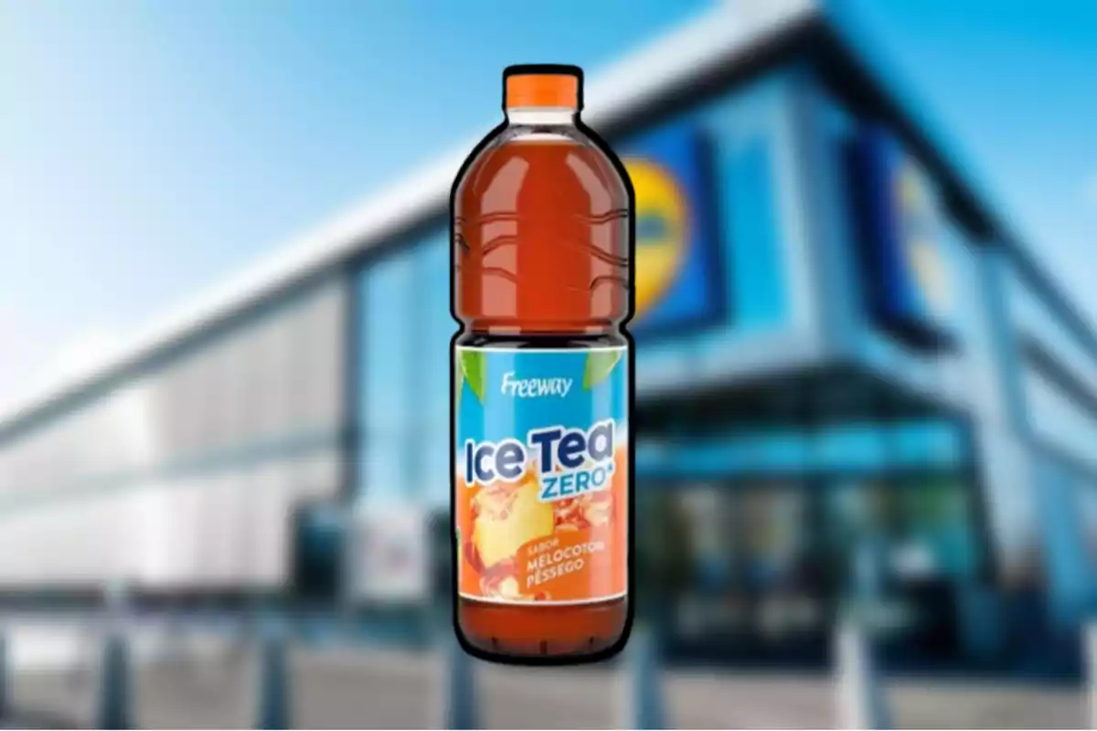 Botella de té helado sabor melocotón de la marca Freeway frente a un supermercado desenfocado Botella de té helado sabor melocotón de la marca Freeway frente a un supermercado desenfocado