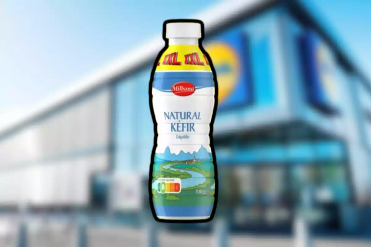 Botella de kéfir natural de la marca Milbona en primer plano con un supermercado desenfocado al fondo Botella de kéfir natural de la marca Milbona en primer plano con un supermercado desenfocado al fondo