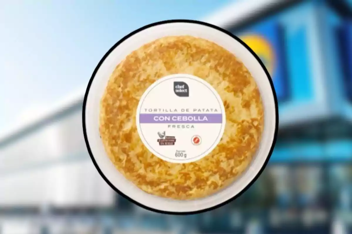Envase redondo de tortilla de patata con cebolla de la marca Chef Select frente a un supermercado desenfocado. Envase redondo de tortilla de patata con cebolla de la marca Chef Select frente a un supermercado desenfocado.