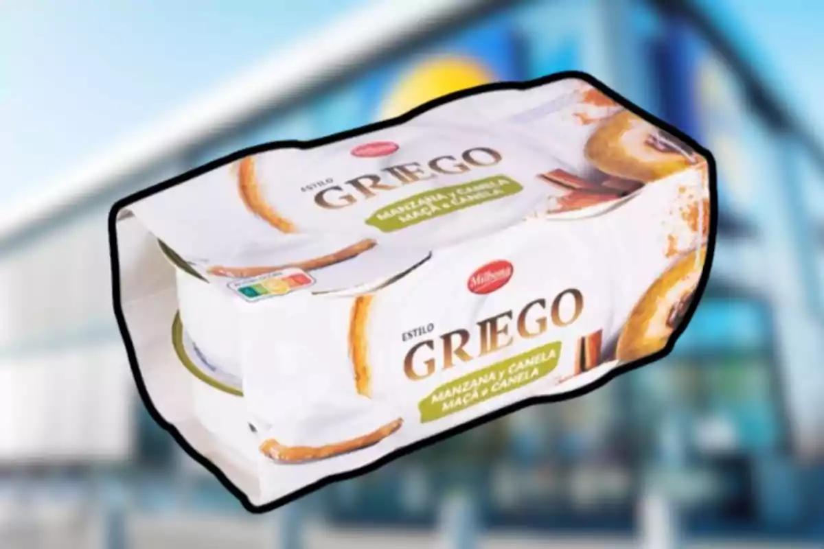 Envase de yogur estilo griego sabor manzana y canela de la marca Milbona sobre un fondo desenfocado de supermercado Envase de yogur estilo griego sabor manzana y canela de la marca Milbona sobre un fondo desenfocado de supermercado
