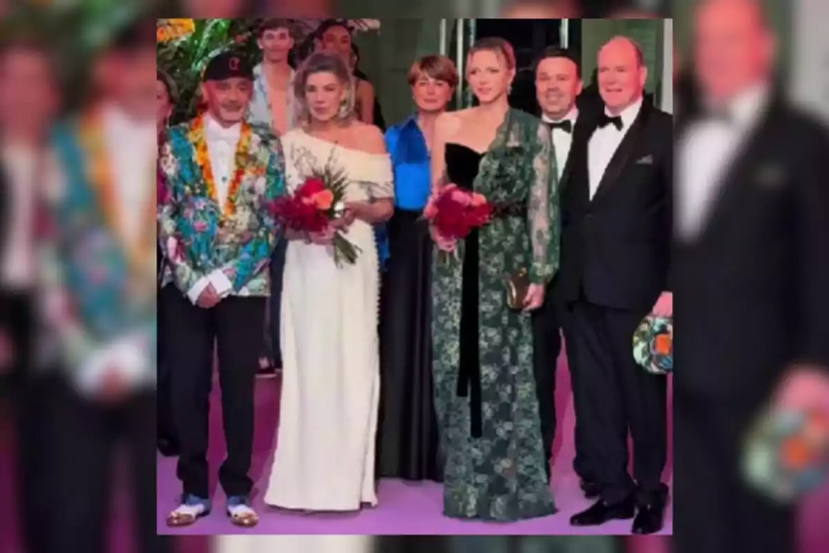 Group of elegantly dressed people posing on a purple carpet during a social event