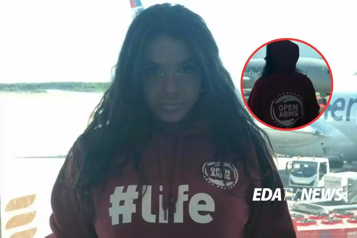 Mujer con sudadera roja de Open Arms y el texto #life en un aeropuerto, con un avión de fondo y un recuadro mostrando la parte trasera de la sudadera