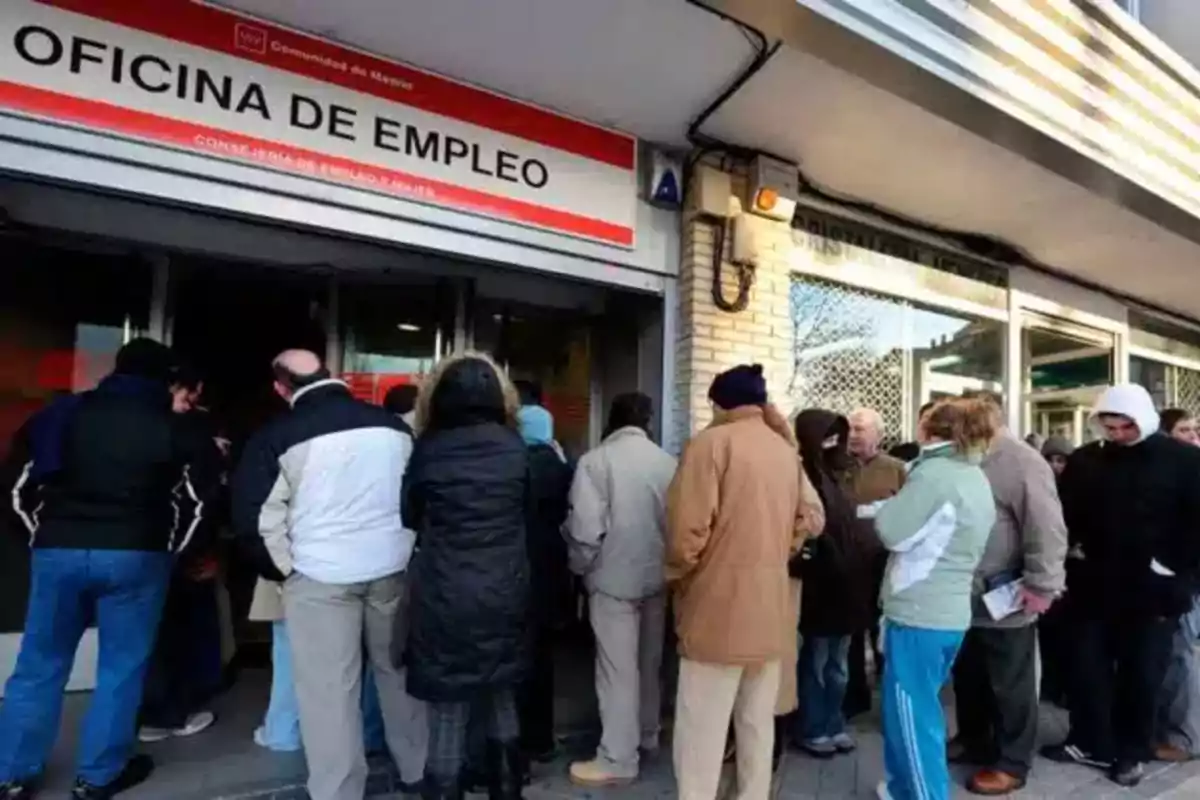 Personas haciendo fila afuera de una oficina de empleo en invierno Personas haciendo fila afuera de una oficina de empleo en invierno