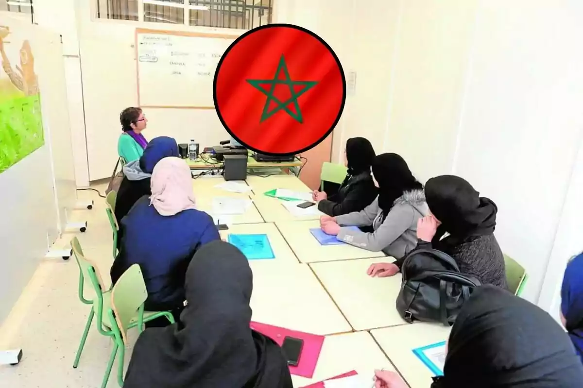 Varias mujeres con velo sentadas alrededor de una mesa en un aula mientras una profesora les da clase y en el centro de la imagen aparece la bandera de Marruecos.