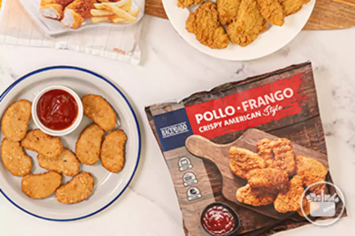 Paquete de pollo empanizado estilo americano junto a un plato con nuggets y salsa de tomate Paquete de pollo empanizado estilo americano junto a un plato con nuggets y salsa de tomate