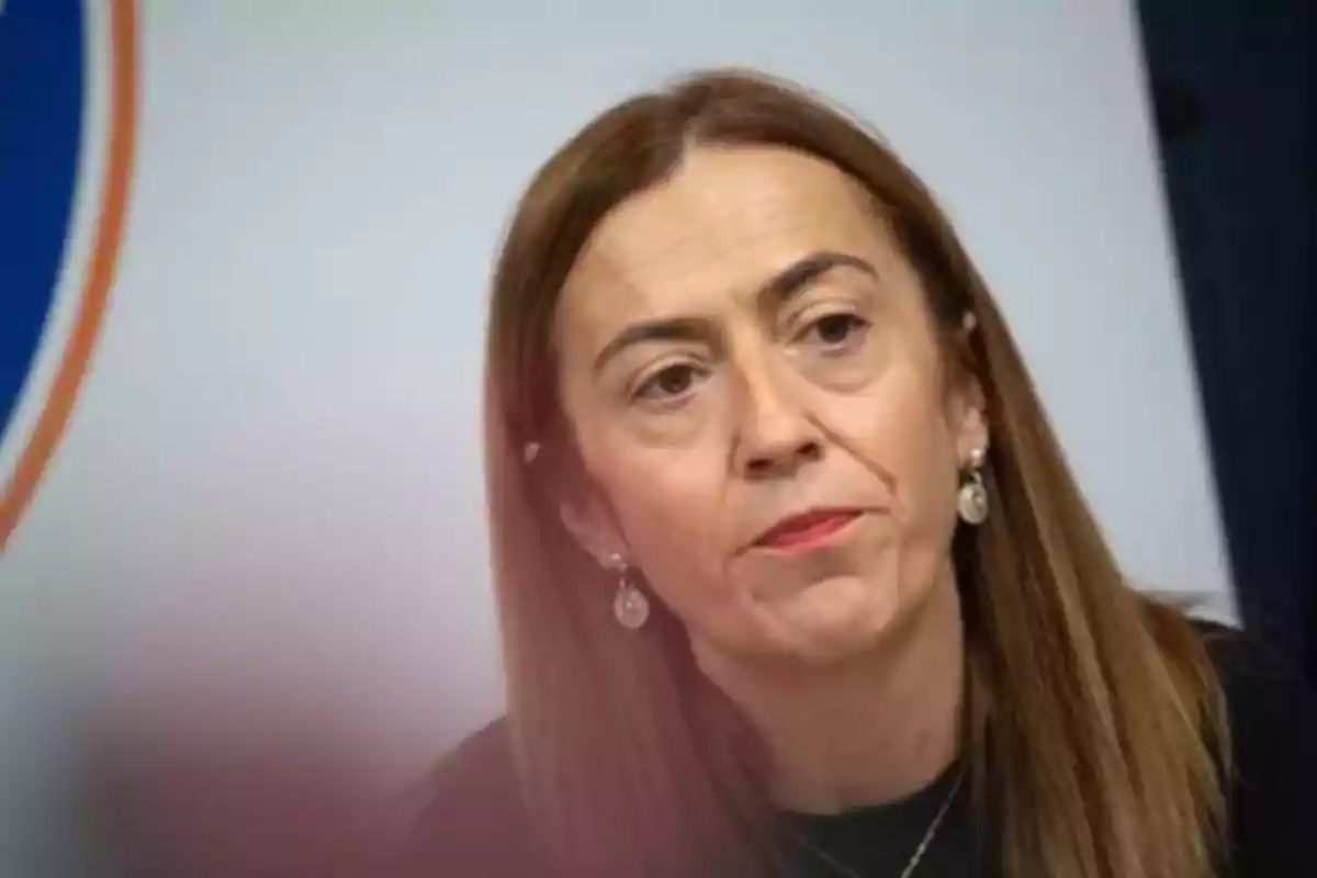 Mujer de cabello lacio castaño claro con expresión seria usando aretes y fondo desenfocado Mujer de cabello lacio castaño claro con expresión seria usando aretes y fondo desenfocado