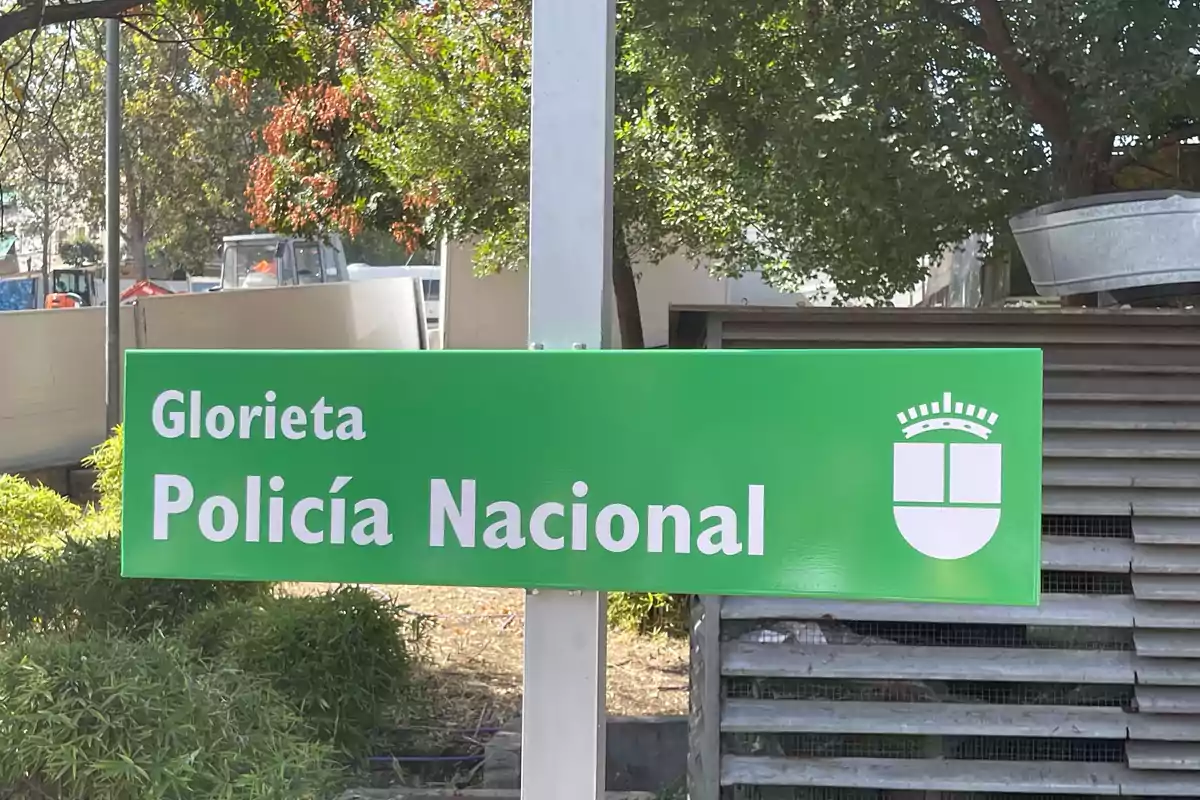 Letrero verde con el texto Glorieta Policía Nacional y un escudo blanco a la derecha Letrero verde con el texto Glorieta Policía Nacional y un escudo blanco a la derecha
