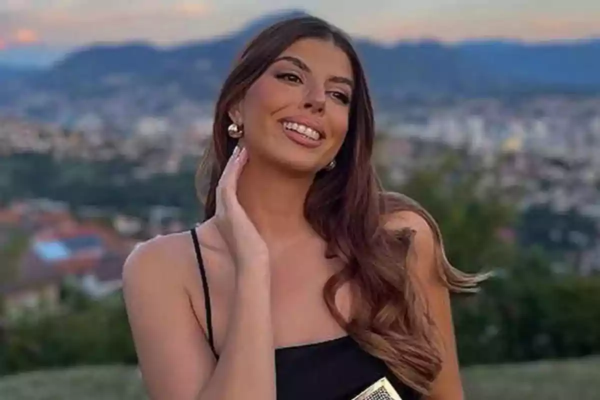 Mujer joven con cabello largo y suelto sonriendo al aire libre con un paisaje de ciudad y montañas al fondo Mujer joven con cabello largo y suelto sonriendo al aire libre con un paisaje de ciudad y montañas al fondo