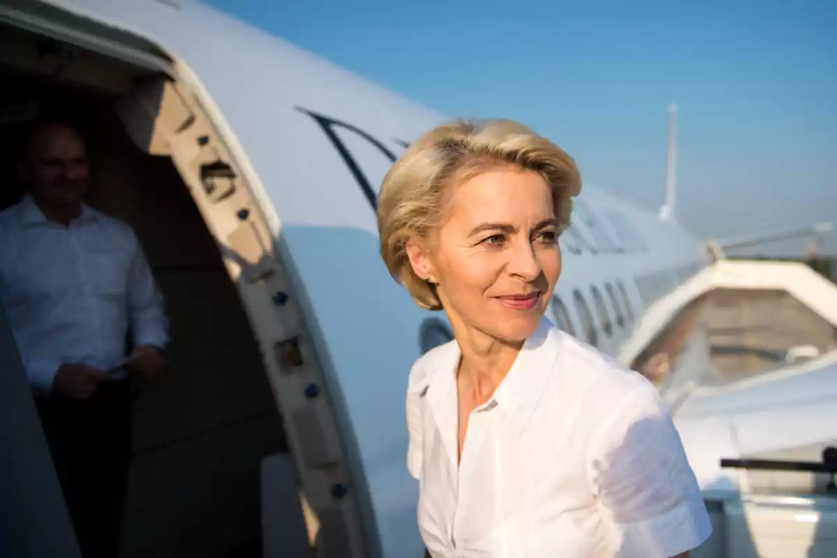 Mujer rubia con camisa blanca saliendo de un avión privado en un día soleado Mujer rubia con camisa blanca saliendo de un avión privado en un día soleado