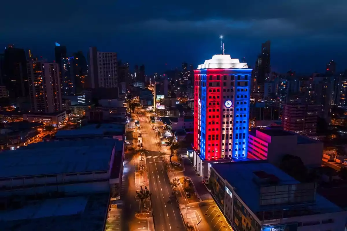 Edificio iluminado con luces rojas y azules en una ciudad moderna durante la noche