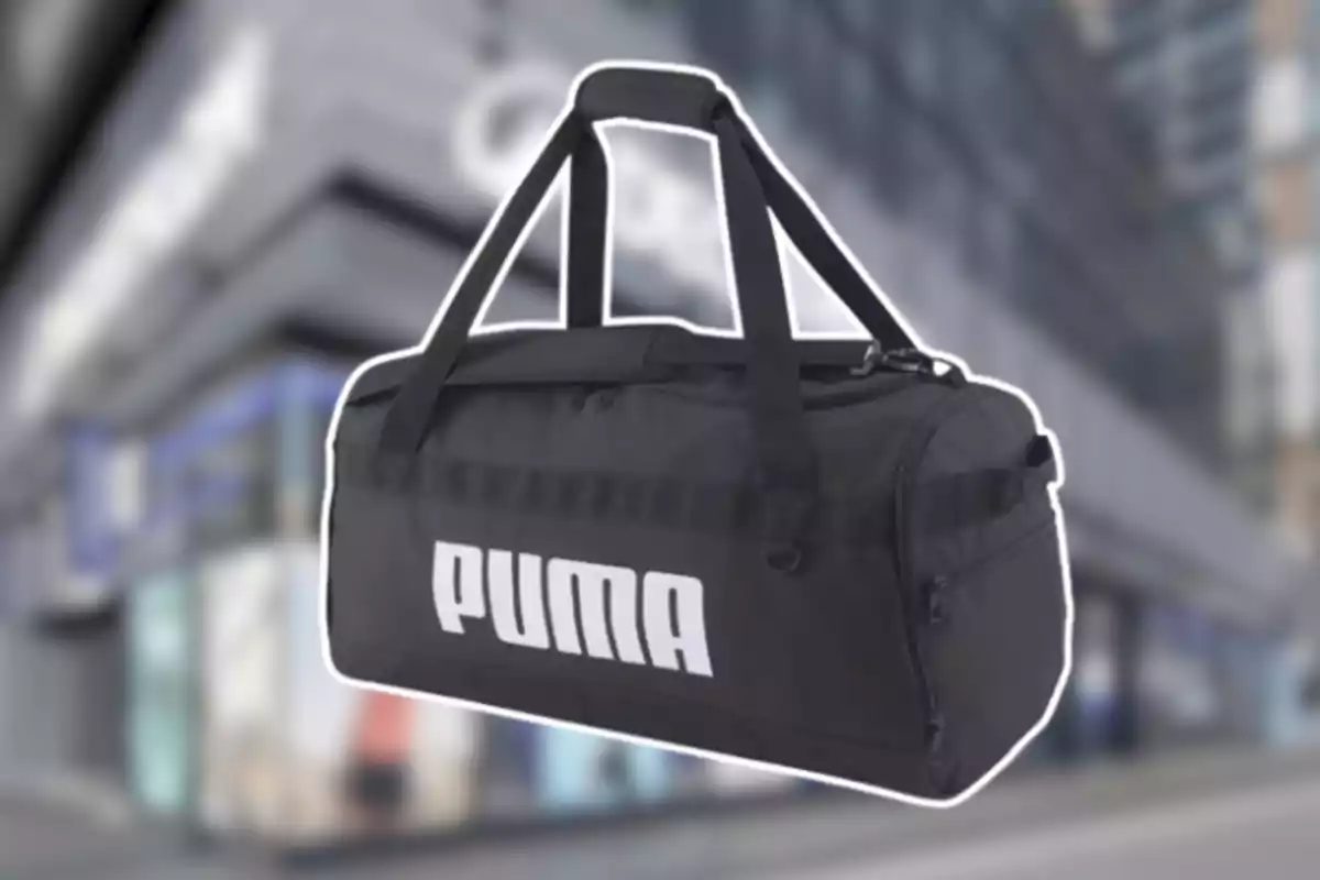 Bolsa deportiva negra de la marca Puma con asas largas sobre un fondo urbano desenfocado Bolsa deportiva negra de la marca Puma con asas largas sobre un fondo urbano desenfocado