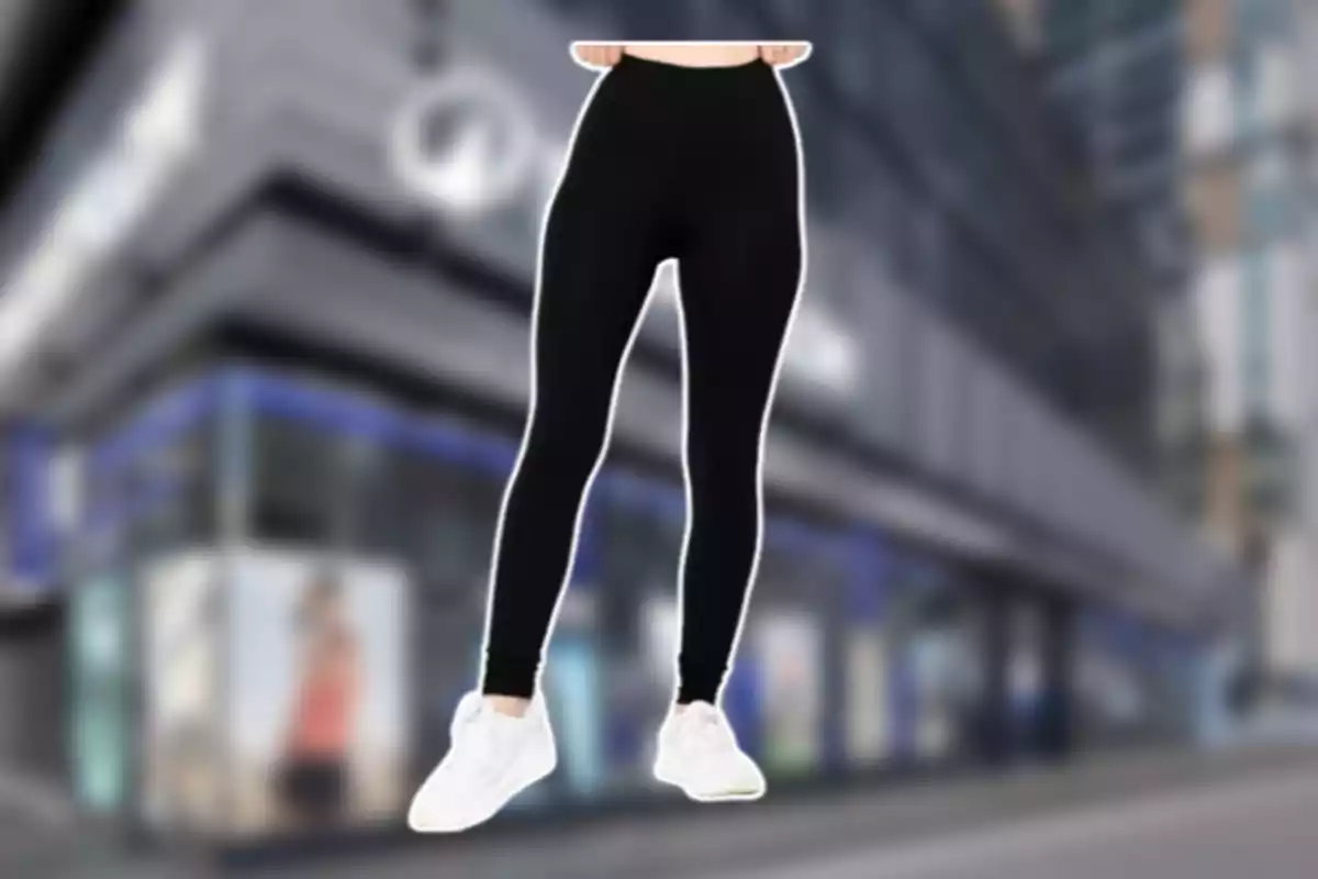 Persona usando leggings negros y tenis blancos frente a un edificio desenfocado