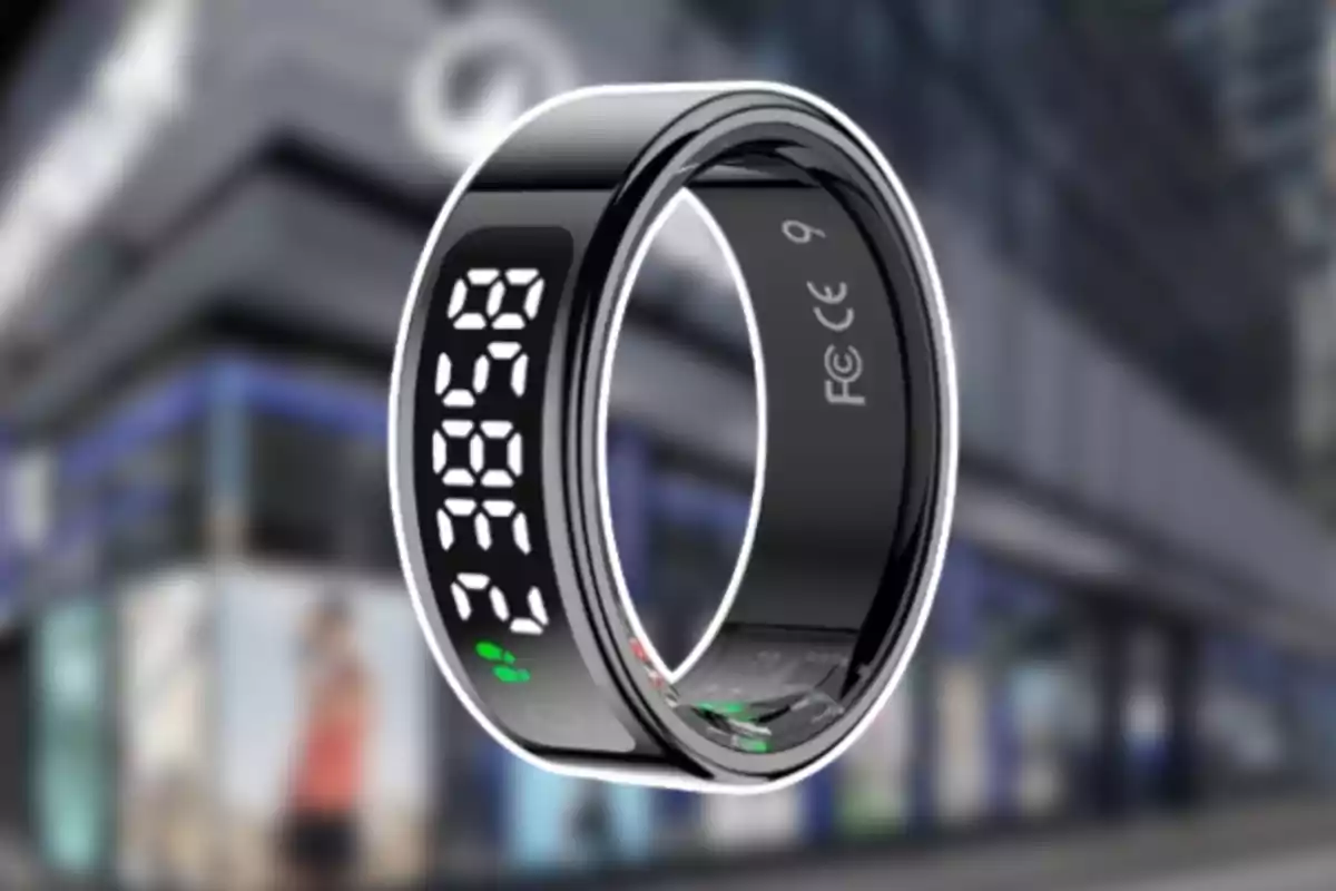Anillo inteligente negro con pantalla digital y números blancos sobre un fondo urbano desenfocado