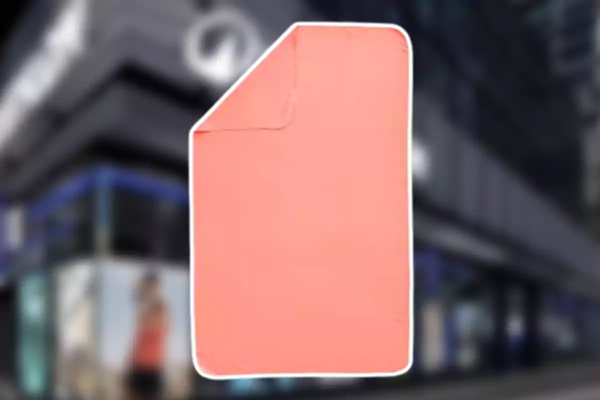 Manta color salmón con borde blanco sobre un fondo urbano desenfocado Manta color salmón con borde blanco sobre un fondo urbano desenfocado