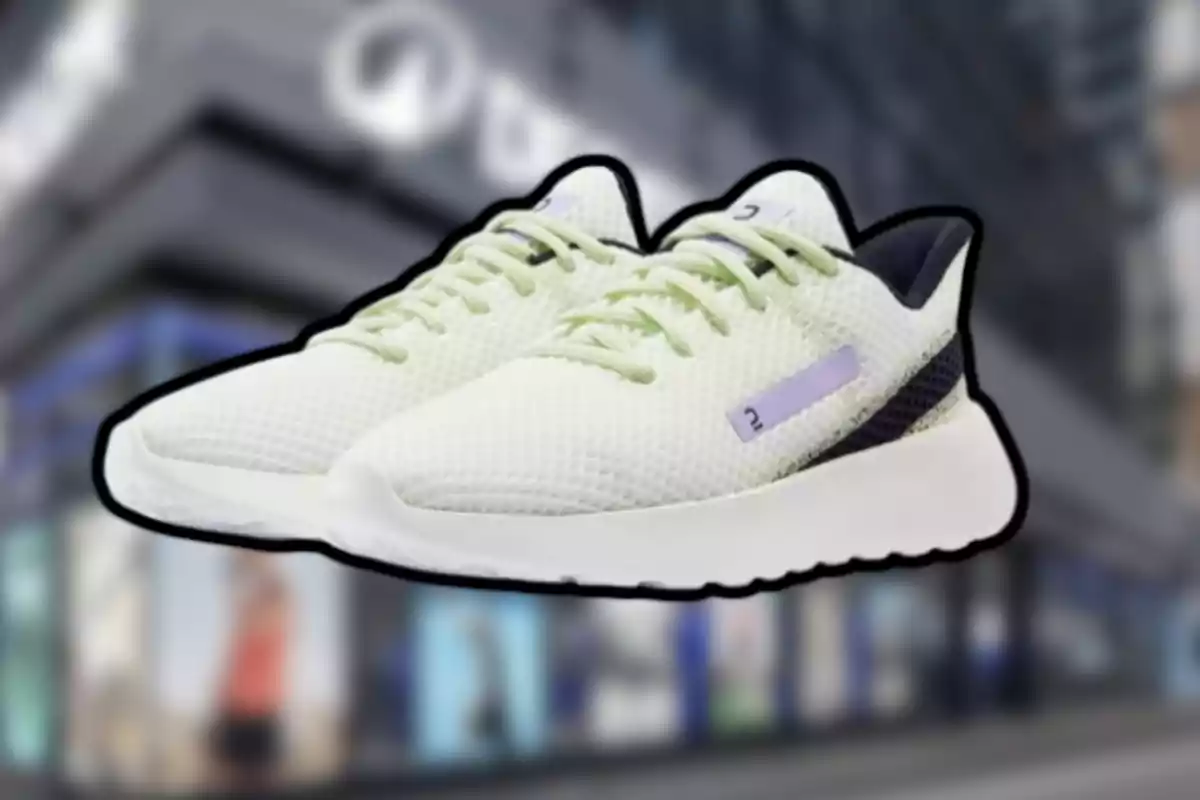 Un par de tenis deportivos blancos con detalles verdes y suela gruesa sobre un fondo urbano desenfocado