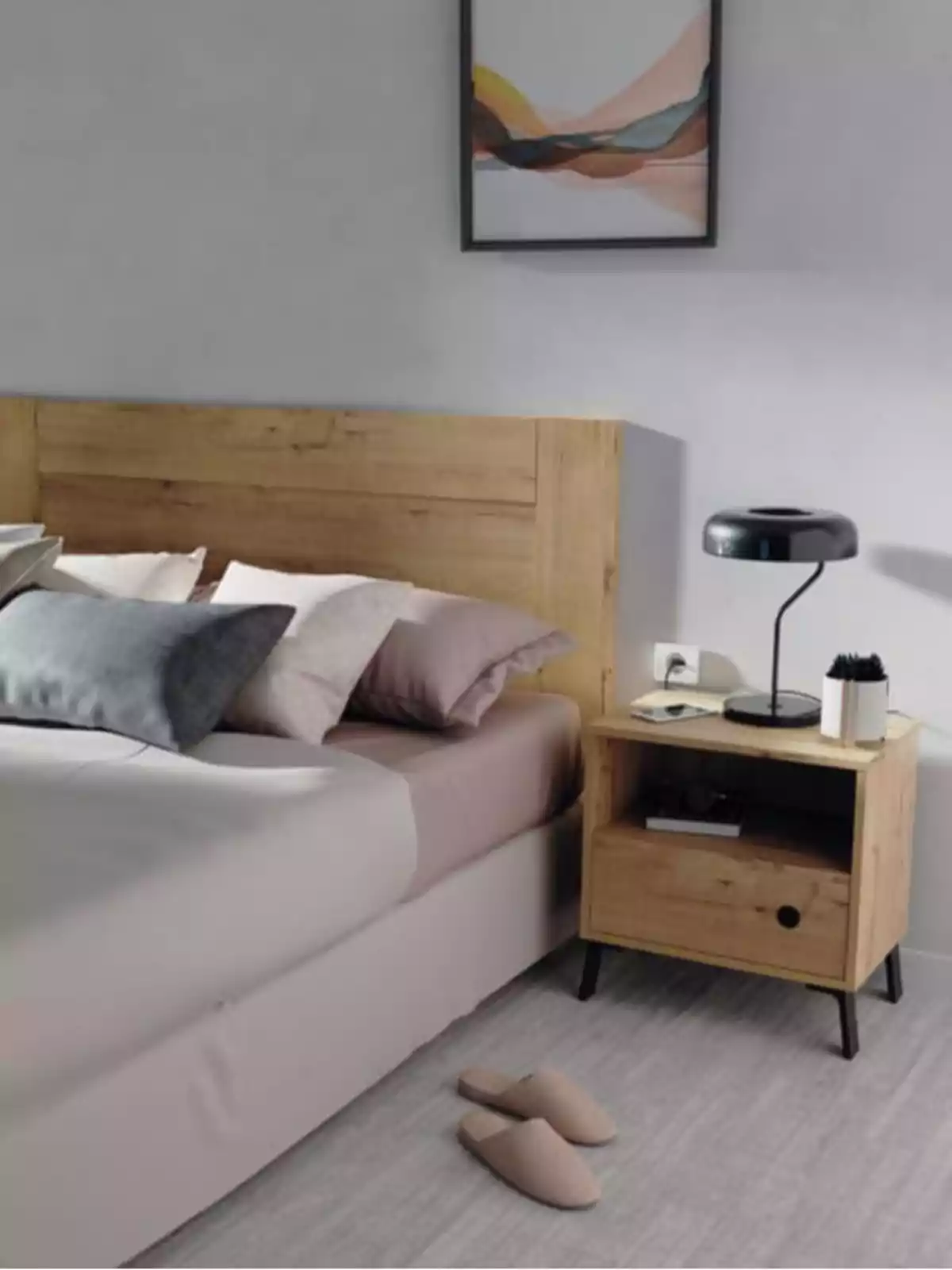 Habitación moderna con cama de madera, mesa de noche, lámpara negra, pantuflas beige en el suelo y un cuadro abstracto en la pared Habitación moderna con cama de madera, mesa de noche, lámpara negra, pantuflas beige en el suelo y un cuadro abstracto en la pared
