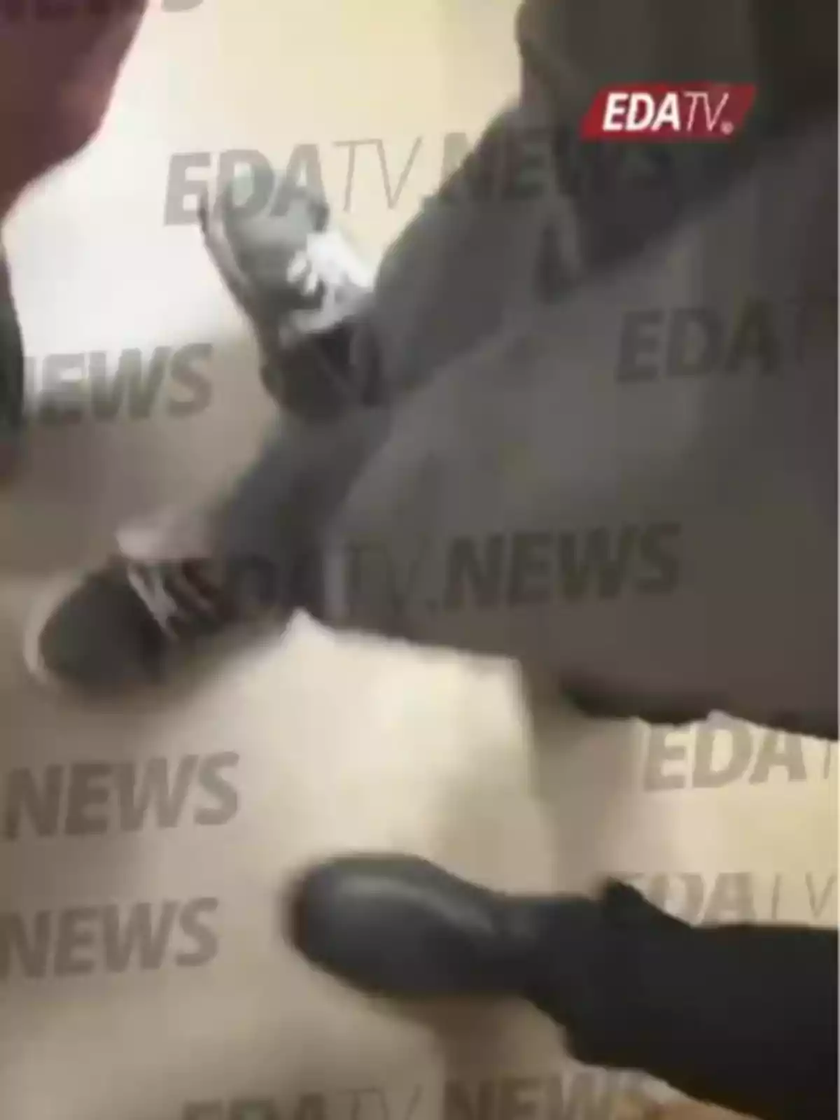 Tres personas de pie vistas desde arriba mostrando solo sus zapatos sobre un suelo claro con el logo de EDATV NEWS repetido en la imagen