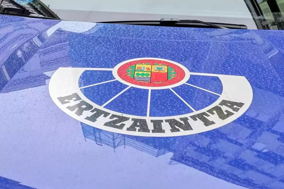 Emblema de la Ertzaintza sobre el capó de un coche patrulla azul Emblema de la Ertzaintza sobre el capó de un coche patrulla azul