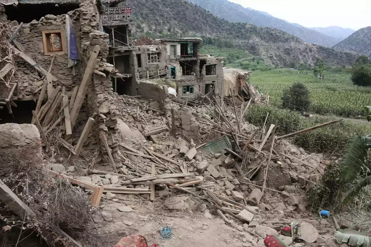 Casas de adobe colapsadas y escombros tras un terremoto en una zona rural rodeada de montañas y campos verdes Casas de adobe colapsadas y escombros tras un terremoto en una zona rural rodeada de montañas y campos verdes
