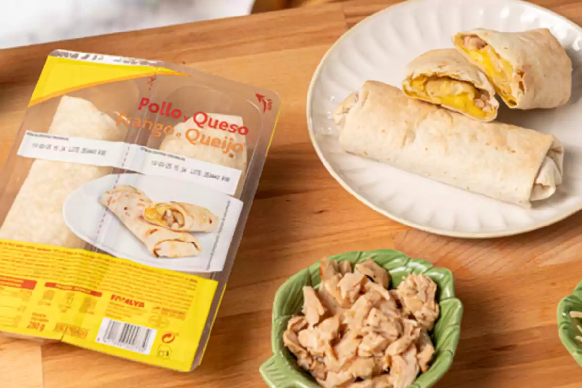 Burritos de pollo y queso en un plato junto a su empaque y un recipiente con trozos de pollo sobre una mesa de madera Burritos de pollo y queso en un plato junto a su empaque y un recipiente con trozos de pollo sobre una mesa de madera