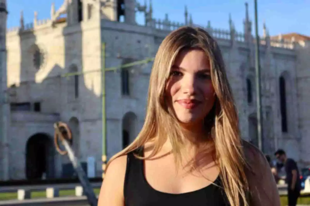 La infanta Sofía de cabello largo y rubio sonríe al aire libre con un edificio histórico de fondo La infanta Sofía de cabello largo y rubio sonríe al aire libre con un edificio histórico de fondo