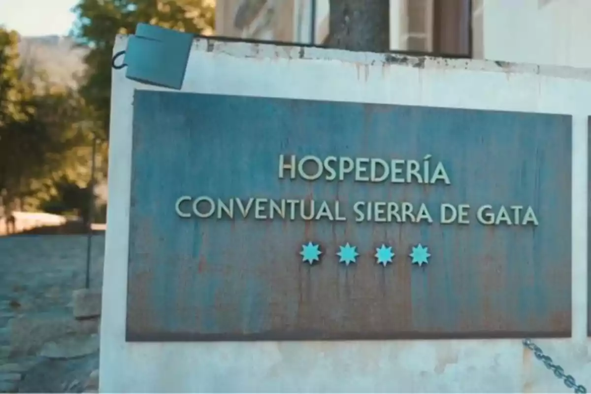 Letrero de metal en la entrada de la Hospedería Conventual Sierra de Gata con cuatro estrellas azules decorativas Letrero de metal en la entrada de la Hospedería Conventual Sierra de Gata con cuatro estrellas azules decorativas