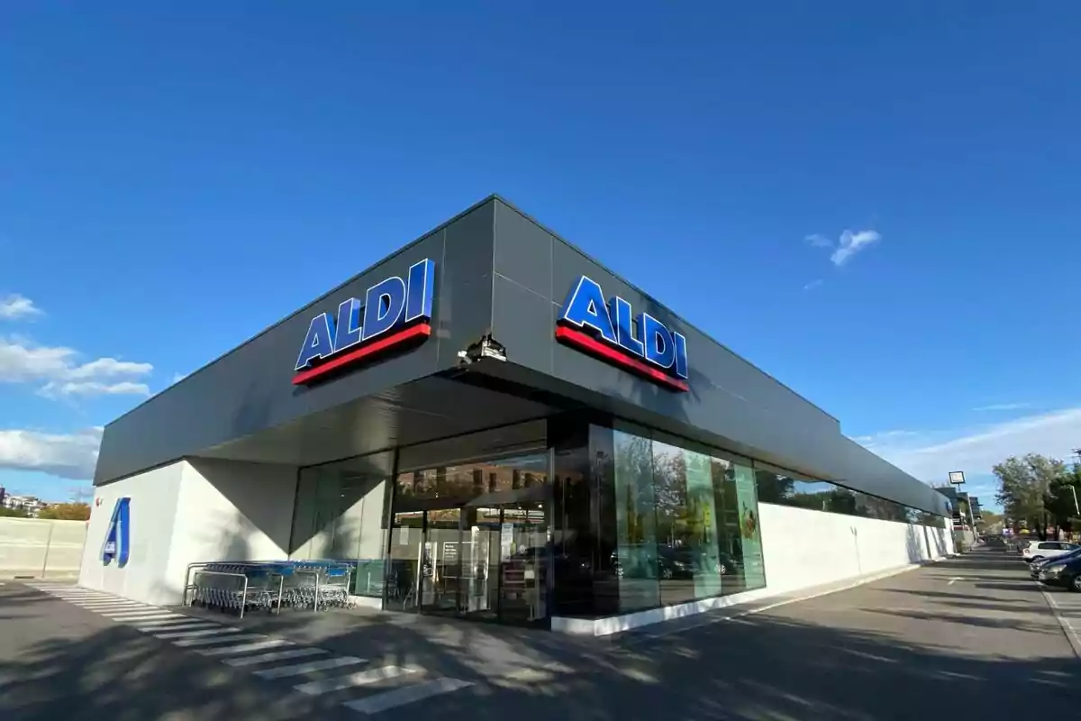 Fachada de un supermercado ALDI con cielo despejado y carros de compra en la entrada.