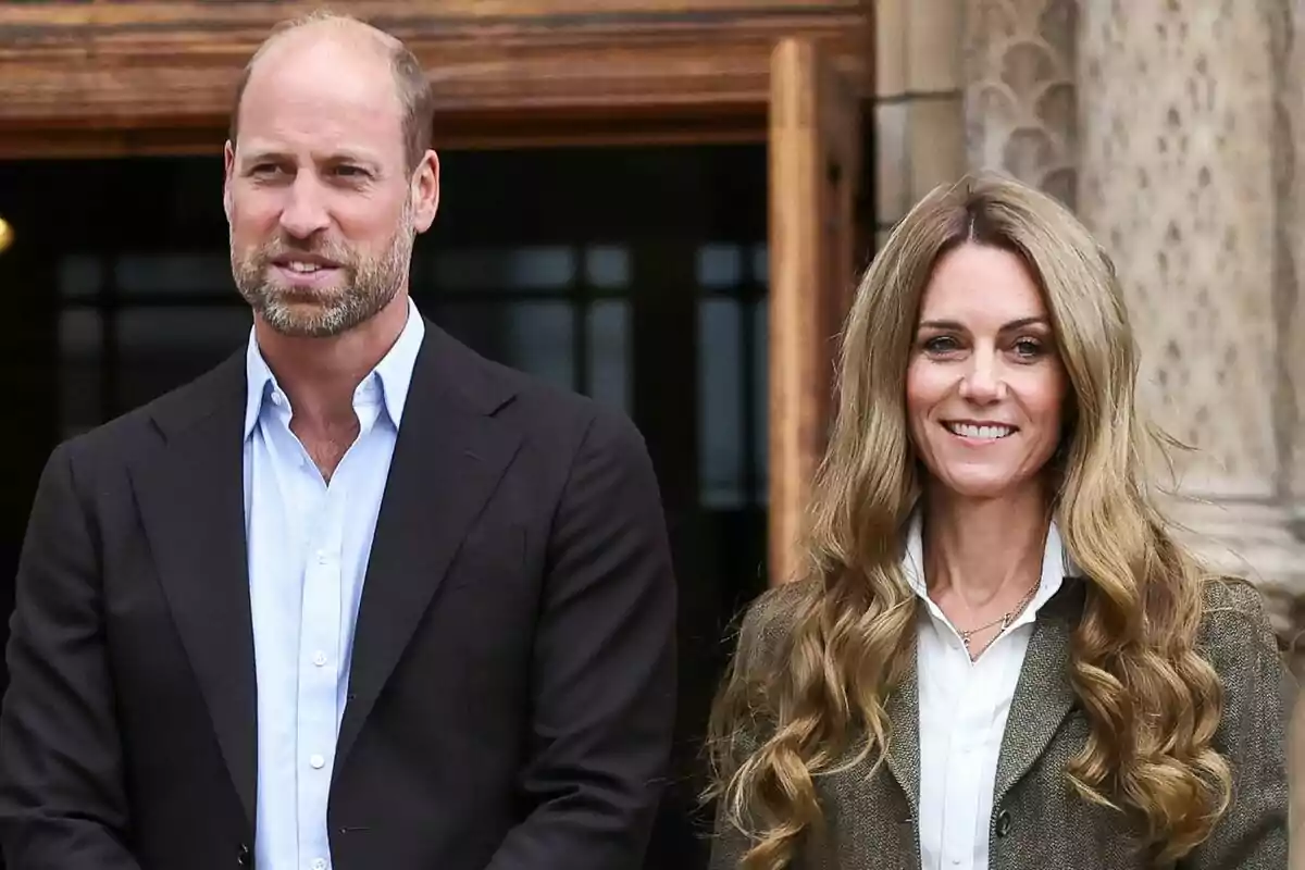 Un hombre y una mujer de pie juntos al aire libre, ambos vestidos de manera formal y sonriendo.