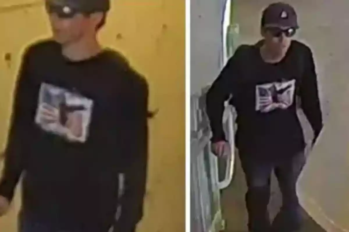 Persona con gafas de sol, gorra oscura y camiseta negra con un diseño en el centro caminando en un pasillo.