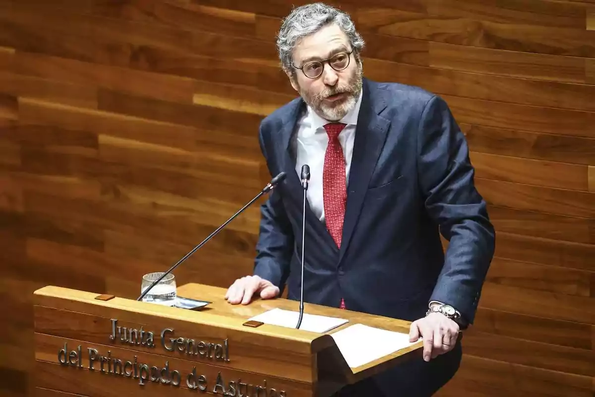 Hombre con gafas y barba hablando en un atril de madera en la Junta General del Principado de Asturias Hombre con gafas y barba hablando en un atril de madera en la Junta General del Principado de Asturias