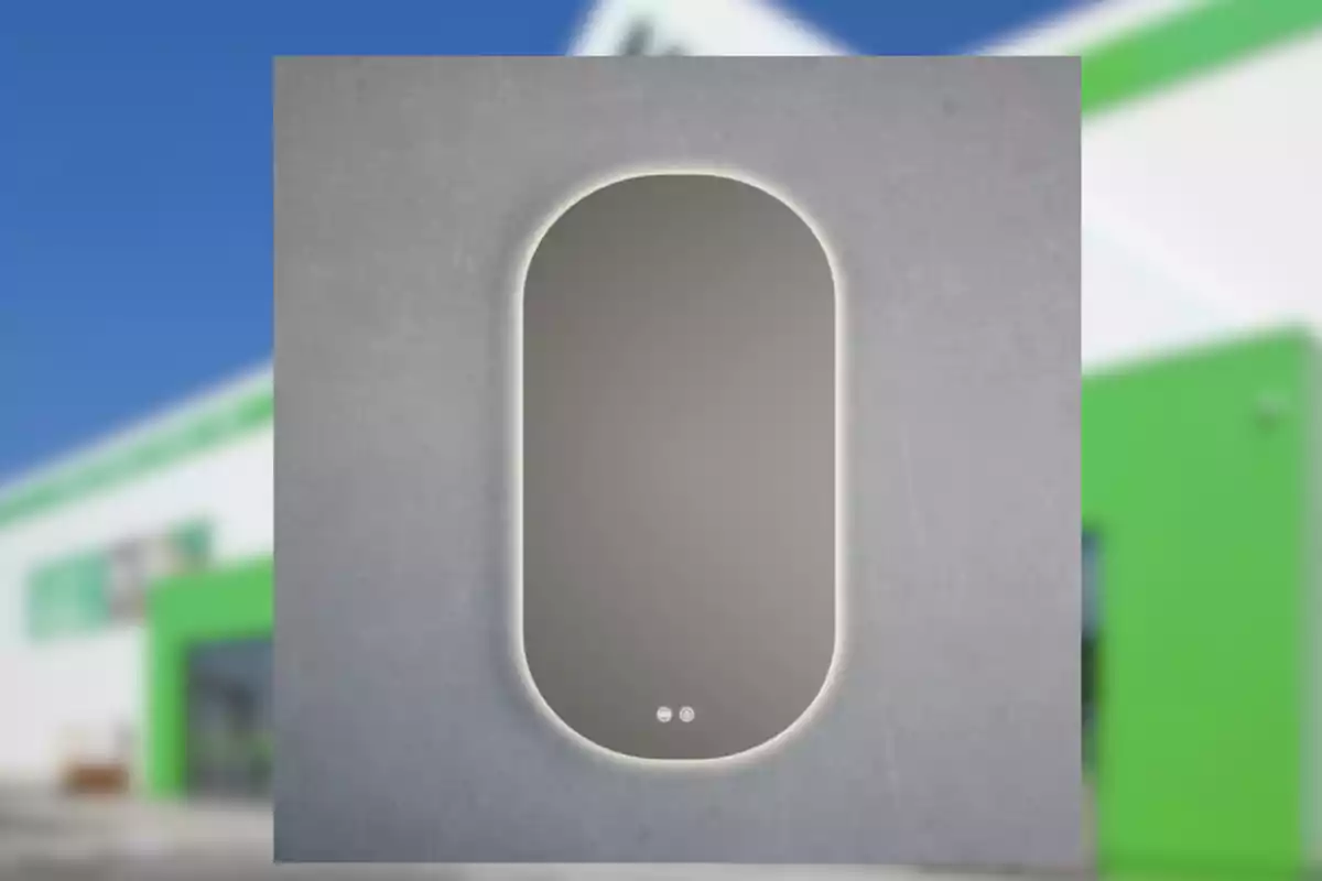 Espejo rectangular con esquinas superiores redondeadas y luz LED en el borde, montado sobre una pared gris