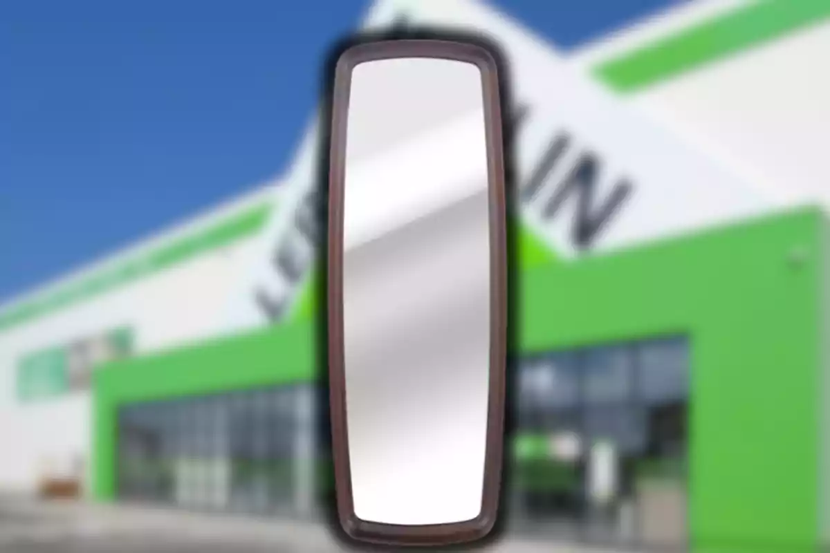 Espejo rectangular con marco oscuro frente a un edificio con fachada verde y blanca desenfocada Espejo rectangular con marco oscuro frente a un edificio con fachada verde y blanca desenfocada