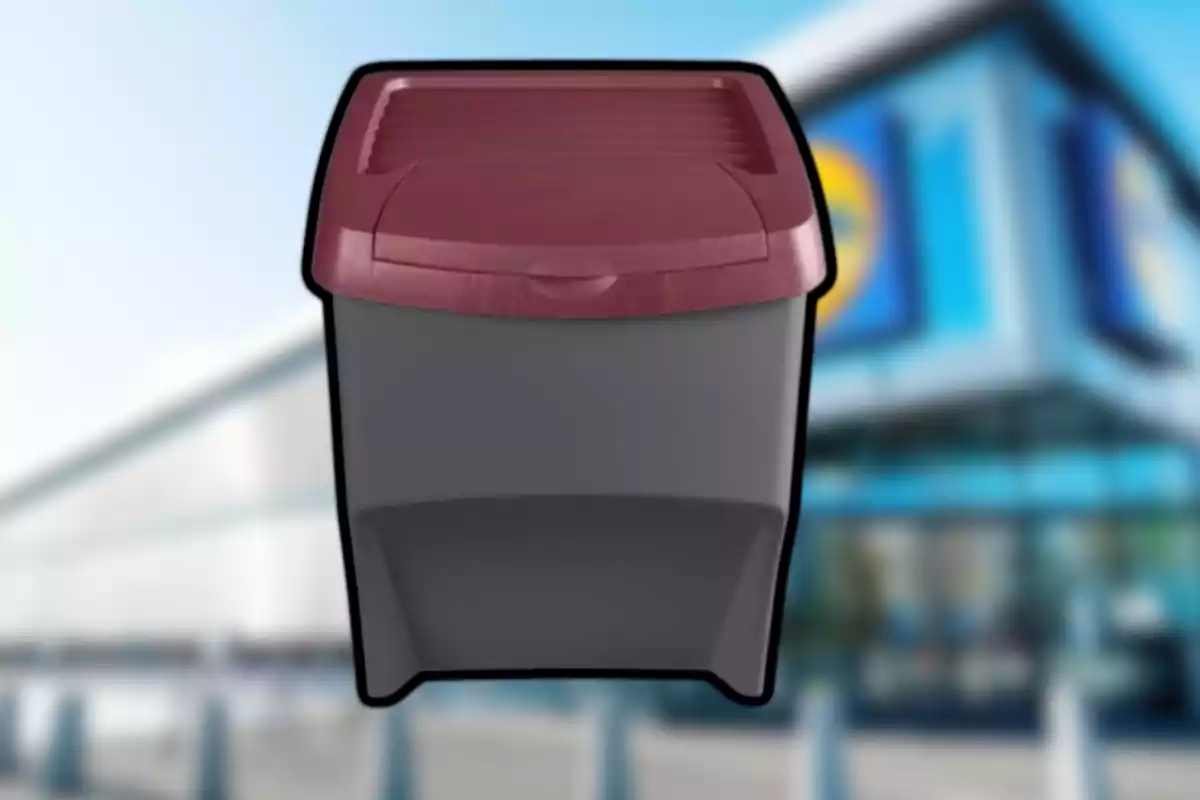 Contenedor de plástico gris con tapa roja frente a un edificio desenfocado Contenedor de plástico gris con tapa roja frente a un edificio desenfocado