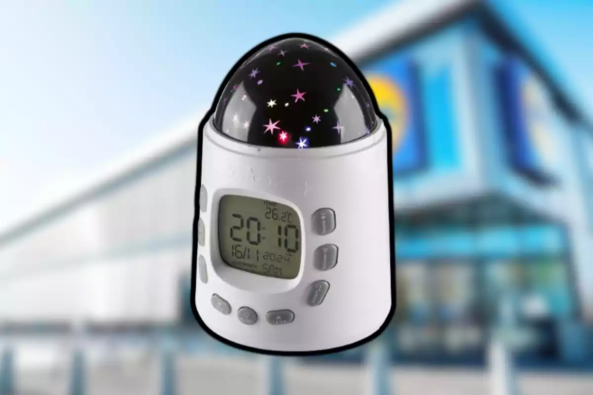 Reloj despertador digital blanco con proyector de estrellas y pantalla LCD mostrando la hora y la temperatura, sobre un fondo desenfocado de un edificio moderno. Reloj despertador digital blanco con proyector de estrellas y pantalla LCD mostrando la hora y la temperatura, sobre un fondo desenfocado de un edificio moderno.