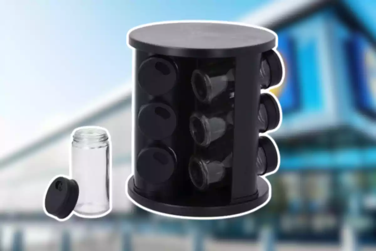 Organizador giratorio negro para especias con frascos de vidrio y tapas negras, uno de los frascos está fuera del organizador y destapado