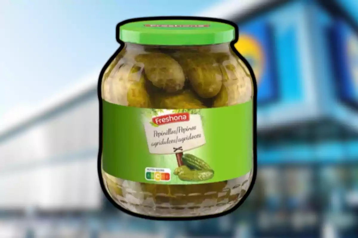Frasco de pepinillos agridulces de la marca Freshona con tapa verde sobre un fondo desenfocado de supermercado Frasco de pepinillos agridulces de la marca Freshona con tapa verde sobre un fondo desenfocado de supermercado