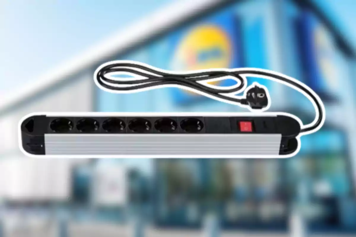 Regleta eléctrica de seis enchufes con interruptor y cable negro sobre un fondo desenfocado de una tienda