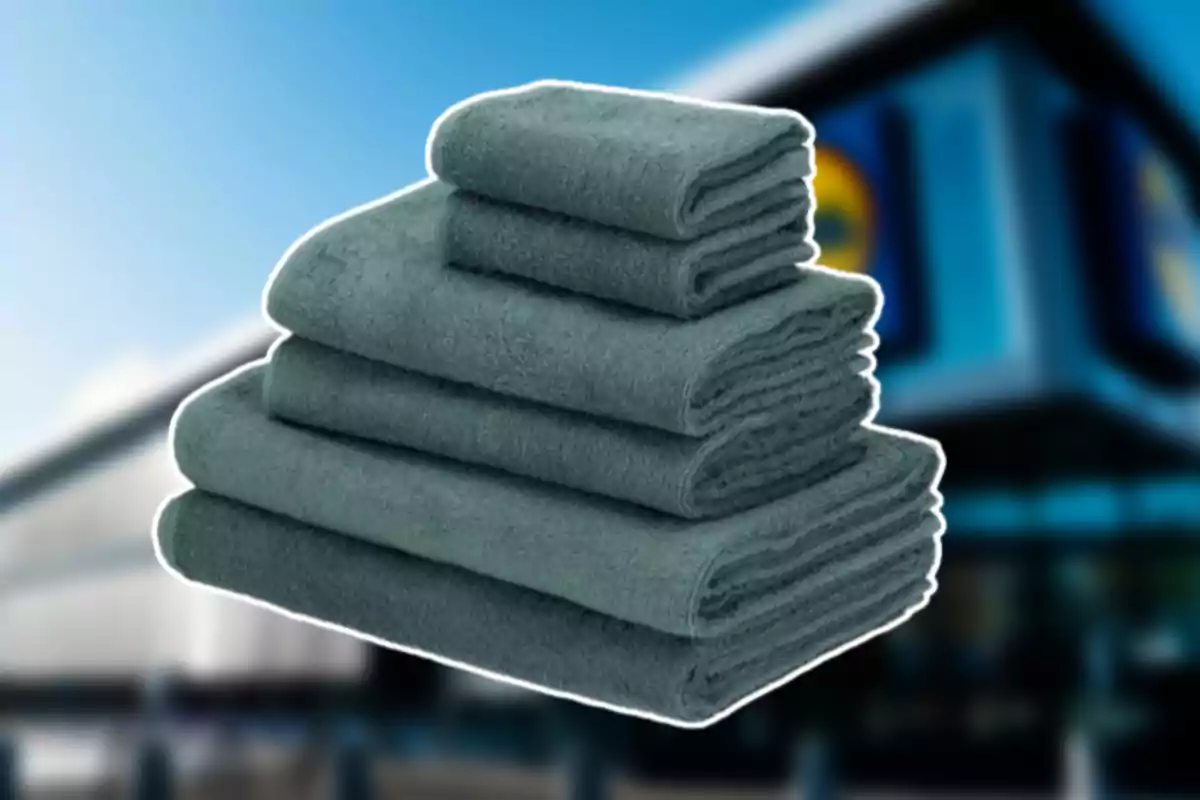 Un juego de toallas grises apiladas frente a una tienda desenfocada
