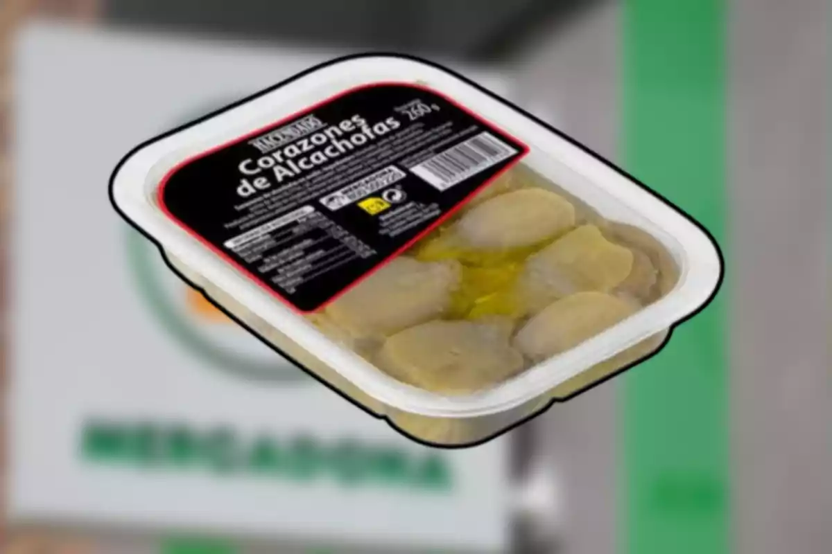 Envase de corazones de alcachofa en aceite de la marca Hacendado sobre un fondo desenfocado de supermercado Mercadona