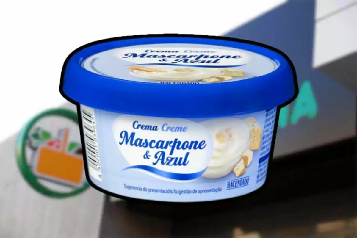 Envase de crema Mascarpone y Azul de la marca Hacendado con tapa azul sobre un fondo borroso de supermercado Envase de crema Mascarpone y Azul de la marca Hacendado con tapa azul sobre un fondo borroso de supermercado