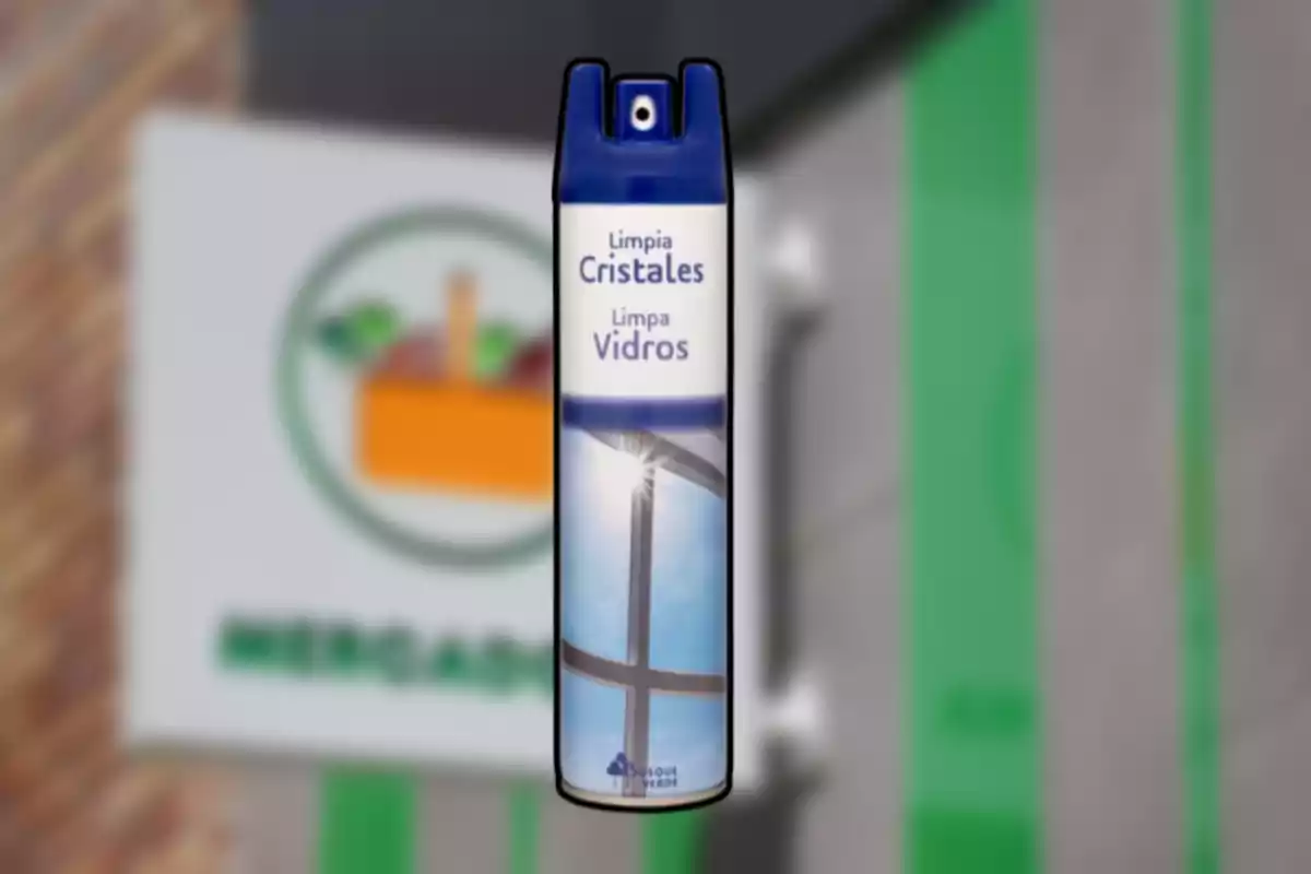 Envase de limpiador de cristales con tapa azul y etiqueta en español y portugués, con fondo desenfocado de un letrero de supermercado. Envase de limpiador de cristales con tapa azul y etiqueta en español y portugués, con fondo desenfocado de un letrero de supermercado.