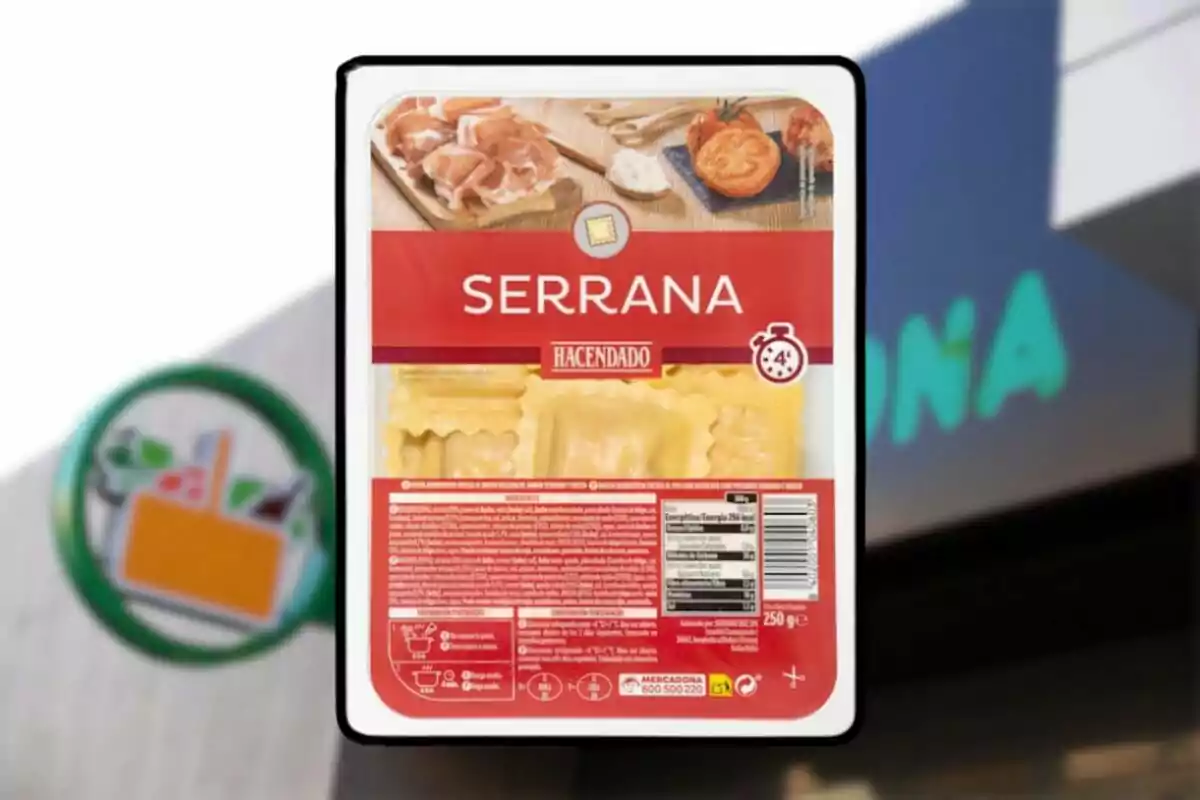 Envase de pasta rellena Serrana de la marca Hacendado frente a un cartel de supermercado Mercadona Envase de pasta rellena Serrana de la marca Hacendado frente a un cartel de supermercado Mercadona